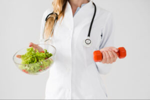 Medical professional promoting physician-guided weight loss with healthy nutrition and exercise, holding a fresh salad and dumbbell to represent balanced wellness care.