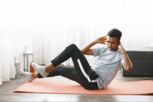 Man performing core and cardio exercises on a fitness mat at home, representing physical activity recommendations for long-term success during semaglutide weight loss therapy.