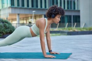 Woman performing outdoor fitness exercises as part of a long-term wellness and healthy lifestyle plan