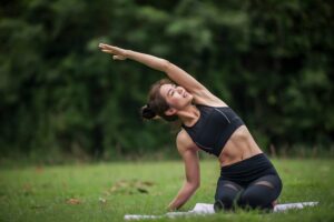 Woman performing outdoor stretching and exercise as part of a comprehensive weight management program